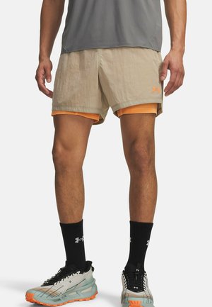 Beige athletic shorts with orange accents and an Under Armour logo, combined with a gray top and black crew socks. Notable lightweight fabric.