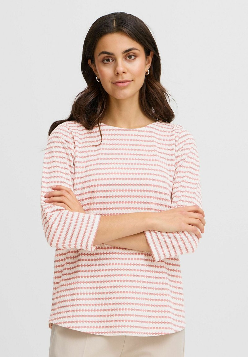 Tricou cu mânecă lungă în roz deschis și alb, cu dungi orizontale. Materialul moale are puncte rotunde de dimensiuni și culori variate.