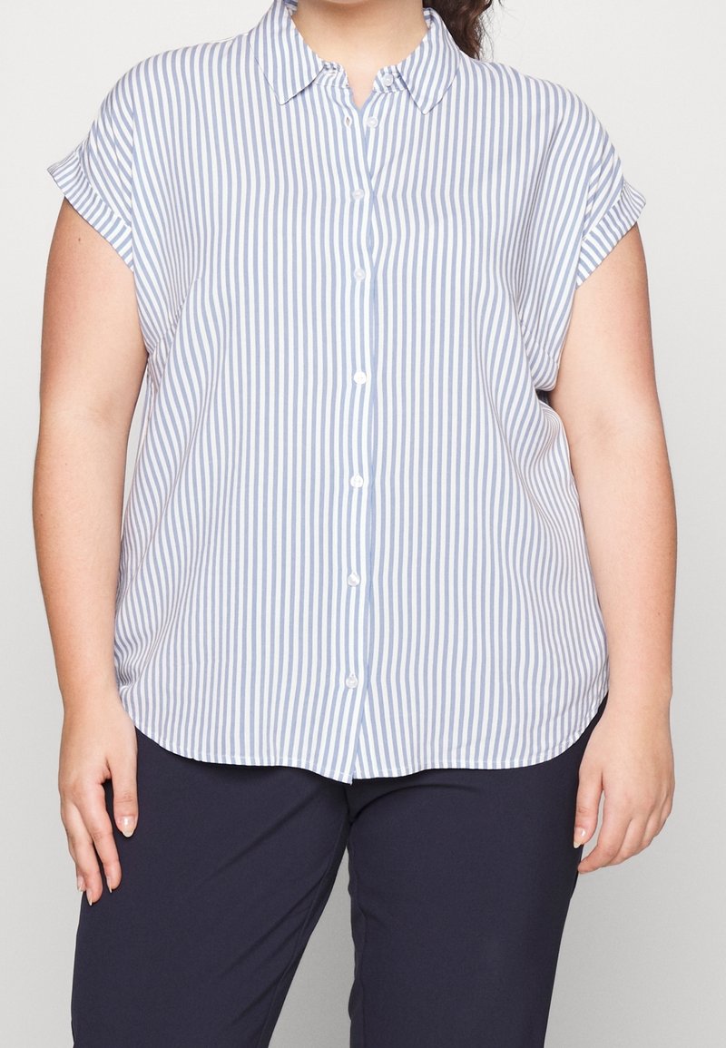 Camisa de botón en azul claro y blanco con rayas verticales, mangas cortas enrolladas, tejido suave, con cuello y dobladillo redondeado.