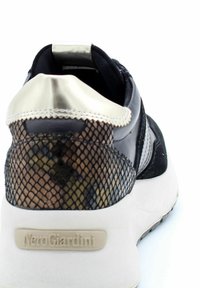 Baskets noires avec un dos en maille noire texturée et en or métallique, semelle blanche et branding "NeroGiardini" sur le talon.