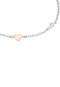 Pulsera de cadena de plata con un pequeño charm en forma de corazón de oro rosa y un acento de gema redonda clara. El diseño es delicado y minimalista.