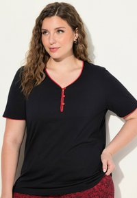 Zwart T-shirt met korte mouwen en een V-hals, versierd met rode randen en drie decoratieve knopen aan de voorkant. Zachte textuur, casual ontwerp.