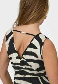 Vestido de rayas blancas y negras con espalda en V profunda, tirantes delgados y cintura fruncida, hecho de una tela texturizada.