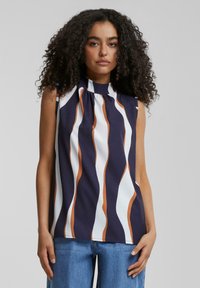 Blouse sans manches avec un col montant, présentant des rayures verticales ondulées en marine, blanc et rouille. Tissu lisse avec des détails de plis au niveau du col.