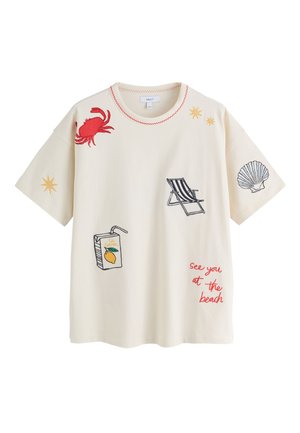 cremefarbenes T-Shirt mit roter Krabbe, gelben Sternen, gestreiftem Liegestuhl, Muschel, Zitronensaftbox und rotem Text mit der Aufschrift "see you at the beach."