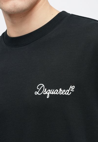 Melnā kokvilnas džemperis ar ribotu apaļu apkakli un baltu izšūtu "Dsquared²" logotipu krūtīs. Gluda tekstūra.