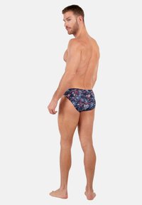 Herren-Schwimmbrieftickets mit einem dunkelblauen Grundton und mehrfarbigen Paisleymustern. Glatter Stoff, tiefer Schnitt und Seitennähte.