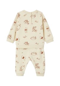 Cremfarbener Baumwoll-Zweiteiler mit braunen Cartoonfiguren, darunter ein Bär und ein Tiger, mit gerippten Bündchen und Bund.