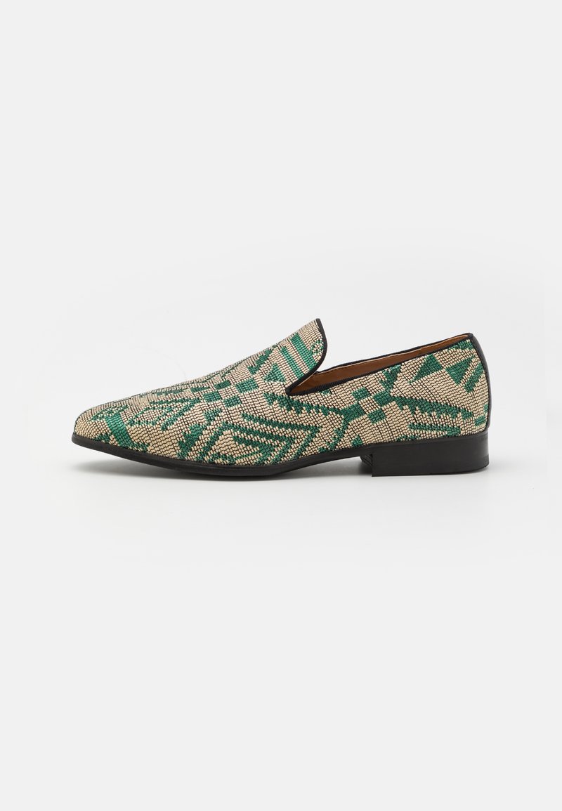 Chaussure à enfiler tissée verte et beige avec un motif géométrique texturé, bordure noire et petit talon en cuir.