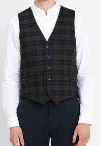 Kamizelka w kratę w ciemnozielonym i czarnym kolorze, z pięcioma guzikami, zapinana na jeden guzik, z klapami w kształcie notch oraz dwiema przednimi kieszeniami. Teksturowana tkanina.