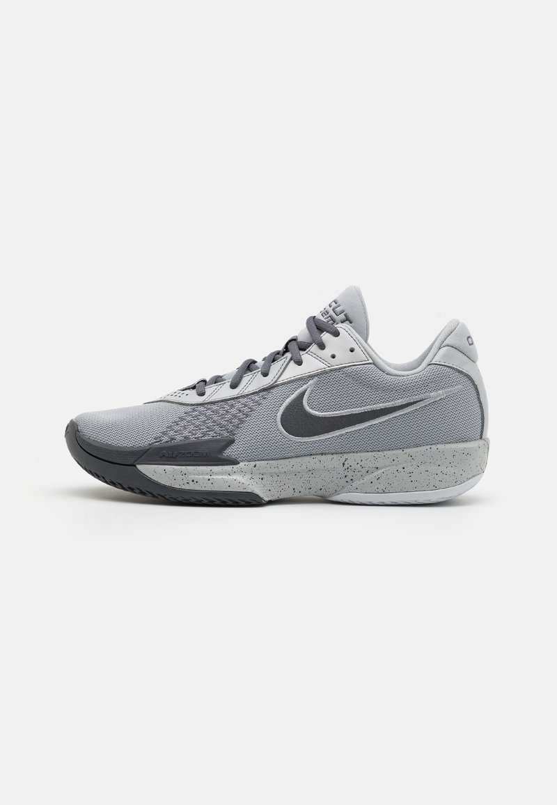 Grå idrettssko med mesh-overdel, syntetiske overlegg, teksturert såle med steinsprutmønster og svart Nike-svoosh.
