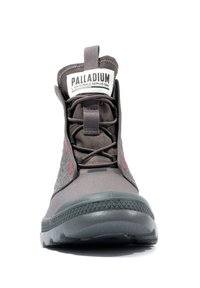 Bottes montantes grises présentant une surface texturée, un col rembourré, un bout rond et des accents rouges contrastants, avec une semelle en caoutchouc.