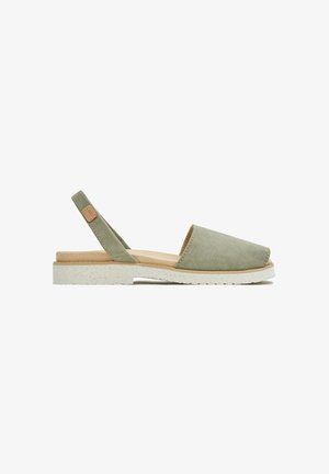 Sandalias verde de ante con talón descubierto y punta redonda, plantilla acolchada beige y suela blanca salpicada texturizada. Toque de cuero marrón en la correa del talón.