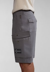 Graue Cargo-Shorts aus leichtem Stoff, mit einer seitlichen Klappentasche, Nähdetails und einem gestickten Flaggen-Patch.