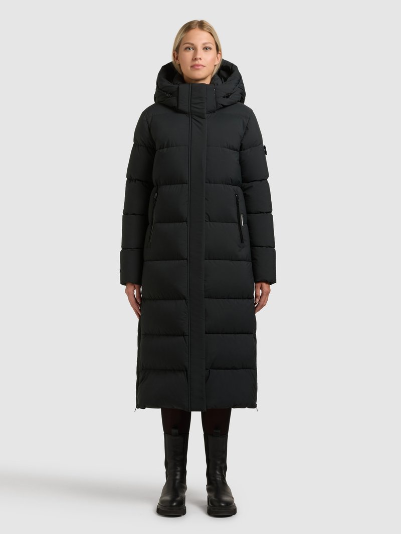 Crna duga jakna od punjene tkanine s kapuljačom, s patentnim zatvaračem sprijeda, prošivenim uzorkom i bočnim džepovima. Ima ravni kroj i mat završnu obradu.