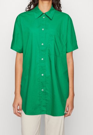 Camicia verde a maniche corte realizzata in tessuto liscio, con chiusura a bottoni, colletto e taschino sul petto.