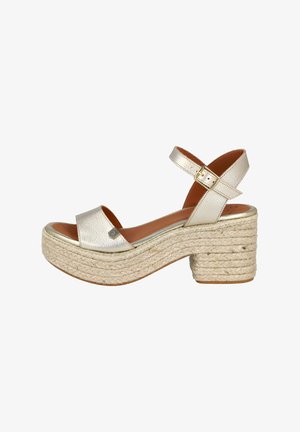 Sandalias de plataforma metálicas doradas con correas frontales anchas, plantilla de yute trenzado y tacón cuadrado. Presentan una correa ajustable en el tobillo y un detalle de logo.