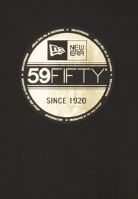 Logo circolare dorato con "59FIFTY" al centro, racchiuso da "NEW ERA" e "SINCE 1920," su uno sfondo nero.