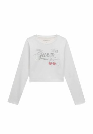 Top corto bianco a maniche lunghe con testo argento "Guess 1981 from L.A. to Japan" e tre grafiche a forma di cuore sul davanti.