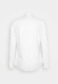 Bílá košile s dlouhým rukávem z lnu, s klasickým límečkem, knoflíkovými manžetami a hladkým, strukturovaným povrchem.