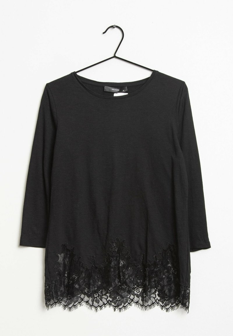 Musta pitkähihainen paita, jossa on pitsireunus kukkakuviolla. Pehmeää kangasta ja pyöreä pääntie. Roikkuu mustalla metallivaatetelineellä.