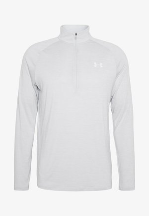 Light gray zip-neck long-sleeve shirt made of soft fabric. Features a fitted design with stretchable sleeves and a small logo on the chest.