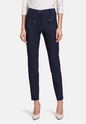 Marineblauwe slim-fit broek van rekbaar materiaal, voorzien van twee met rits afgesloten zakken en een knoopsluiting, met een soepele textuur en een op maat gemaakte stijl.
