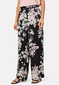 Pantalon noir à motif floral à coupe large, avec un motif floral rose et vert, taille élastique et tissu léger.