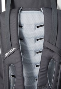 Dark gray SALWA backpack, featuring a padded interior with a light gray textured fabric and ventilation holes for breathability.