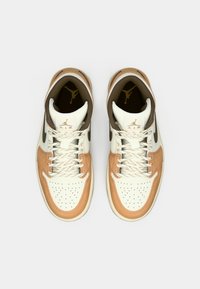 Fehér bőr felsőrésszel, tejes bőr díszítésekkel és barna részletekkel ellátott magasszárú sportcipők. Jellemzőik a lekerekített orr, perforációk és texturált cipőfűzők.