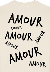 Crème-kleurige sweatshirt met grote zwarte teksten die "AMOUR" in verschillende groottes en hoeken over de voorkant verspreid weergeeft. Gemaakt van katoen.