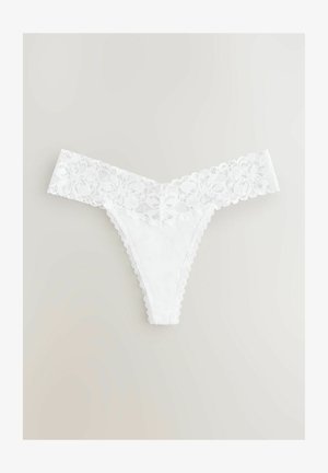 Biały koronkowy string z kwiatowym wzorem w pasie, z falbaniastymi krawędziami i gładką bawełnianą bazą, zaprojektowany z myślą o minimalnym zakryciu.