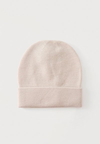 Bonnet tricoté couleur crème avec revers plié, présenté à plat sur fond clair.