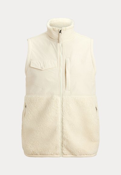 Cream-colored sleeveless vest with a soft, fluffy lower section, zippered front, and two side pockets; features a front chest pocket.