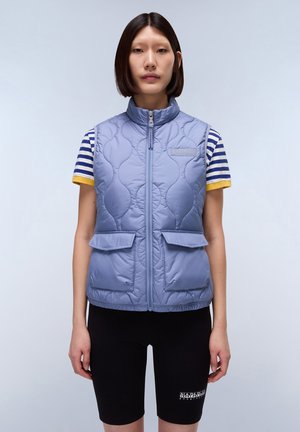 Gilet matelassé bleu clair avec un col haut, une fermeture éclair à l'avant et deux poches avant. Associé à une chemise à rayures à manches courtes et un short noir.