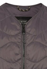 Grau gesteppte Jacke mit Rundhalsausschnitt, ausgestattet mit einem zentralen Reißverschluss in Schwarz mit einem strukturierten Zipper und einem kontrastierenden Innenkragen.