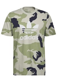 T-shirt camouflage in verde e beige con accenti scuri, realizzato in cotone. Presenta un logo Adidas bianco centrato sul petto. Maniche corte.