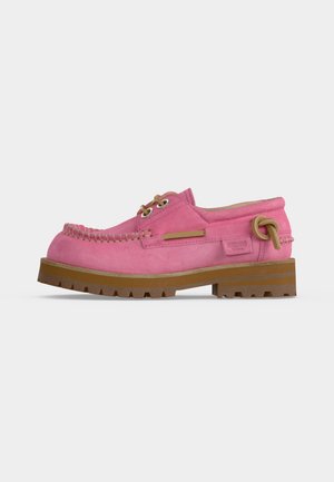 Rosa ruskind loafers med mokasinsyning, tanfarvede snøredetaljer, tykk brun sål og sidesløjfe, vist fra ydersiden.