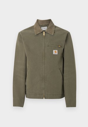 Olivengrønn Carhartt arbeidsjakke med kordfløyelkrage, glidelås foran, glidelåslomme på brystet og to sidelommer.