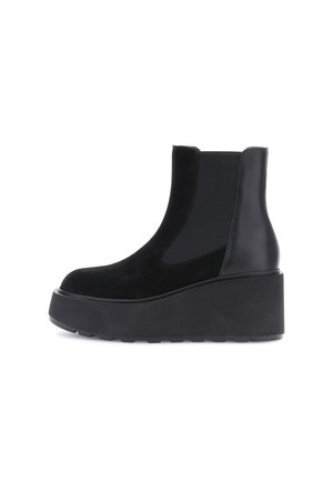 Stivale nero con suola piattaform in gomma. Presenta una combinazione di pelle liscia e camoscio, pannelli laterali elasticizzati e punta arrotondata.