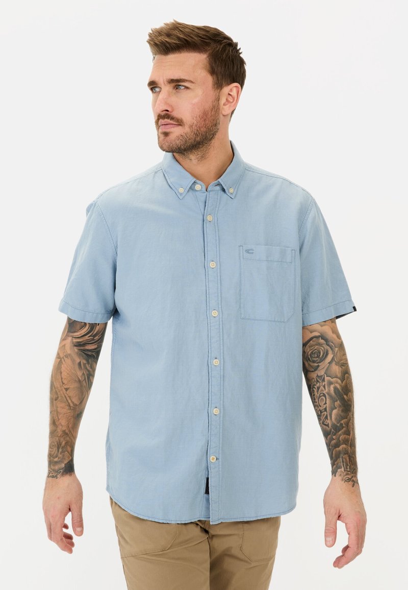 Lichtblauwe kortekorte mouwen overhemd met knopen in een zachte stof, met een zak en een subtiele logo-detail op de borst. Casual en relaxed fit.