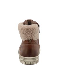 Hnědé kožené kotníkové boty s huňatým krémovým límcem, bočním zipem a texturovanou bílou podrážkou, s malým kovovým akcentem na zadní straně.