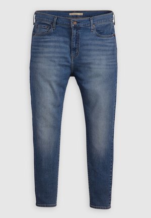 Jeans in denim blu con una vestibilità slim, design a cinque tasche e una leggera scoloritura sulle gambe. Finiti con accessori in ottone e dettagli di cucitura.