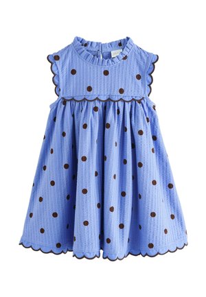 Light blue sleeveless toddler dress with brown polka dots, scalloped edges, and a ruffled neckline with a back button closure.