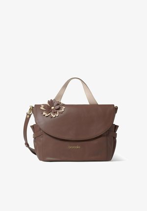 Brown leather handbag with a rounded flap, cream accents, and a floral appliqué. Features gold hardware and an adjustable shoulder strap.