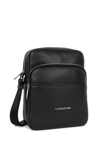 Borsa a tracolla in pelle nera con finitura texturizzata, apertura con zip e tasca frontale. Caratterizzata da accessori in argento e marchio in rilievo, "LANCASTER."