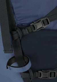Donkerblauwe rugzakdetail met verstelbare zwarte nylon schouderbanden en een plastic gesp, voorzien van een gestructureerde stof en een lus om spullen vast te maken.
