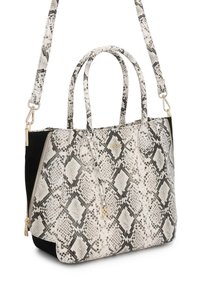 Bolso tote estructurado con patrón de serpiente en blanco y negro, asas dobles superiores, correa de hombro desmontable y detalles en cremallera y logo en tono dorado.