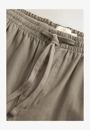 Hall hõbedased elastikvöödiga lühikesed püksid, millel on kangastrapiga tõmbesüsteem, sisaldavad peent tekstuuri ja õmbluse detaile. Sisetagi on nähtav vööl.