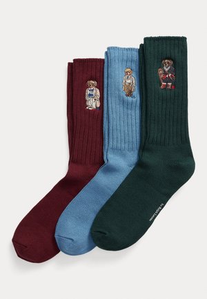 Three pairs of ribbed socks in burgundy, light blue, and dark green, each featuring embroidered cartoon characters in varied outfits.